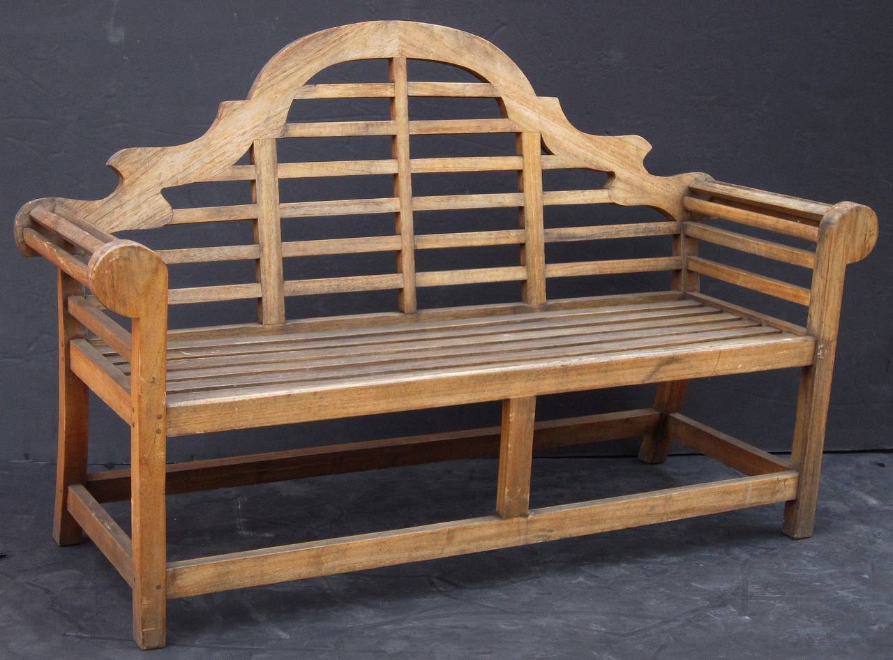 A vintage Lutyens style teak bench after Sir Edwin Lutyens, the British architect renowned for his imaginative, classic designs throughout England, Ireland, and New Delhi.

Featuring a high arched back for comfort and graceful rolled arms - an