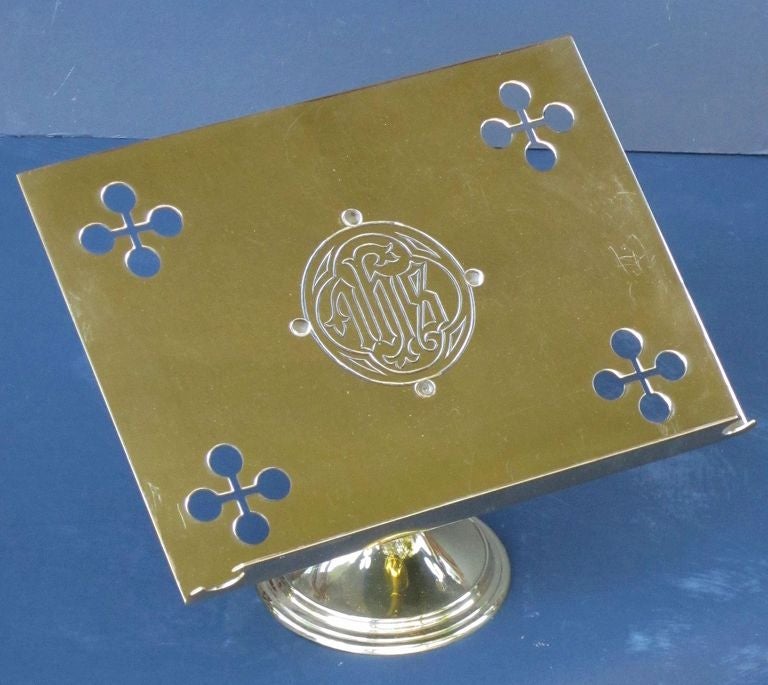An English missal, lectern, or book stand of brass, featuring a Christian symbol or christogram in the center reading IHS here deriving from the Greek word for Christ. The top attached to a weighted base.

Suitable for displaying many books - an