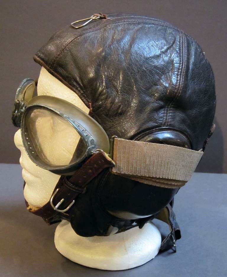 A German Luftwaffe pilot's winter flight helmet of leather with goggles.
Featuring a fleece lining and receivers with clear celluloid covers.
The helmet has a Hersteller tag-Fl. Kopfhaube Gr: 55-Deutschetelephonwerke und Kabelindustrie A.G.

A