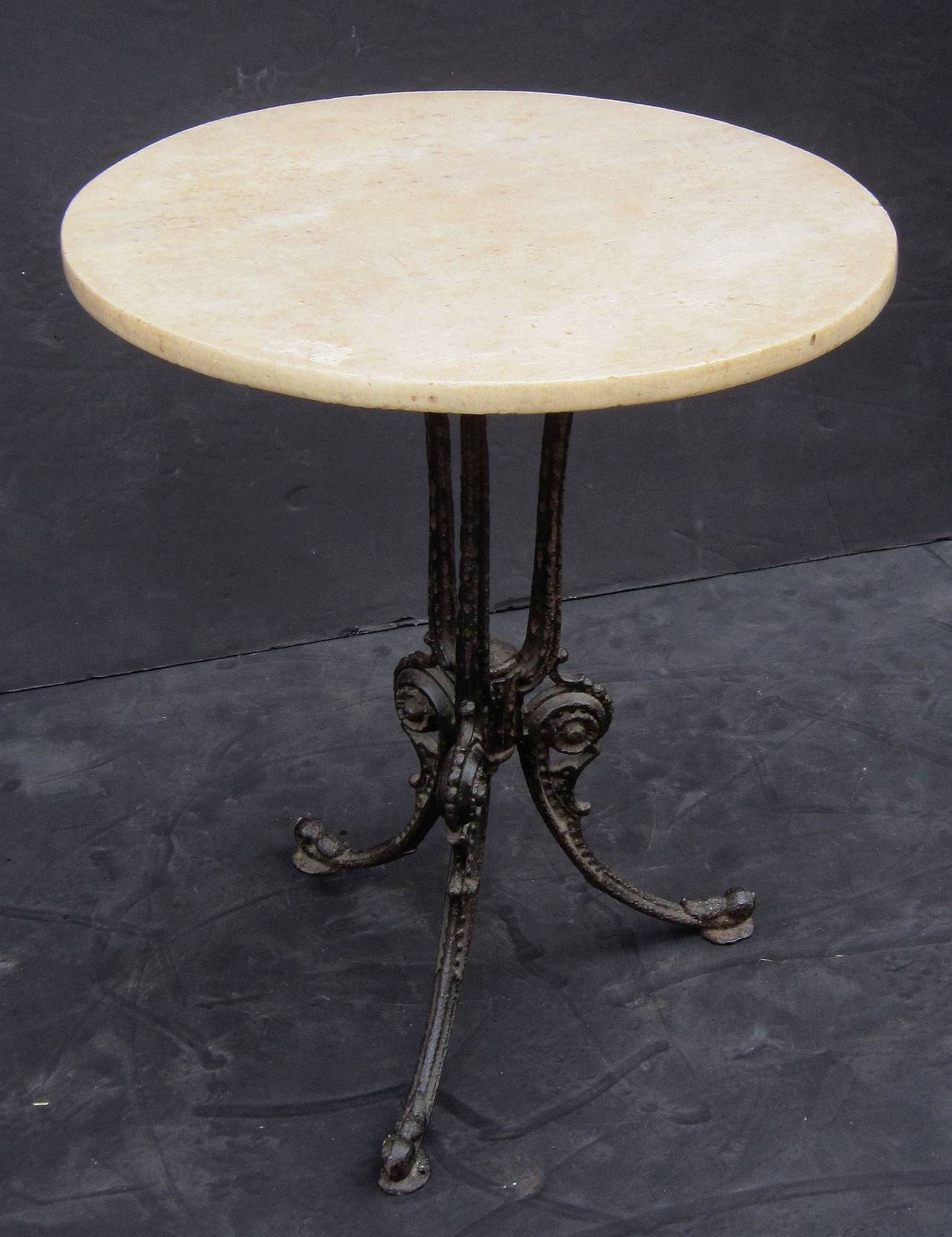 A handsome English bistro table featuring a round or circular marble top mounted to a tripod pedestal base of cast iron with a decorative scroll design.

Great for a garden or patio!