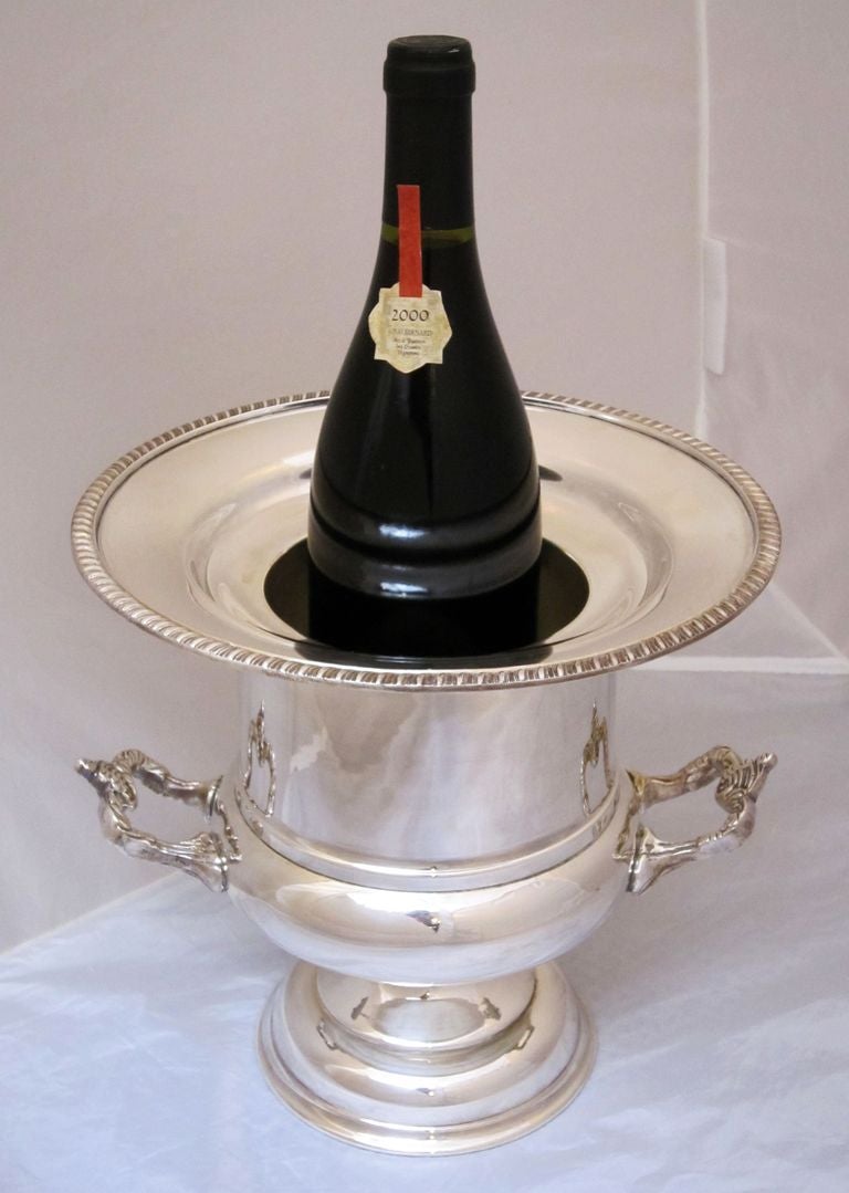 An English champagne bucket or wine bottle cooler featuring a Classical shape with a rolled-edge top and opposing handles on the urn-shaped body. Includes removable fitted insert for different bottle diameters.
Can be used as a soda siphon holder