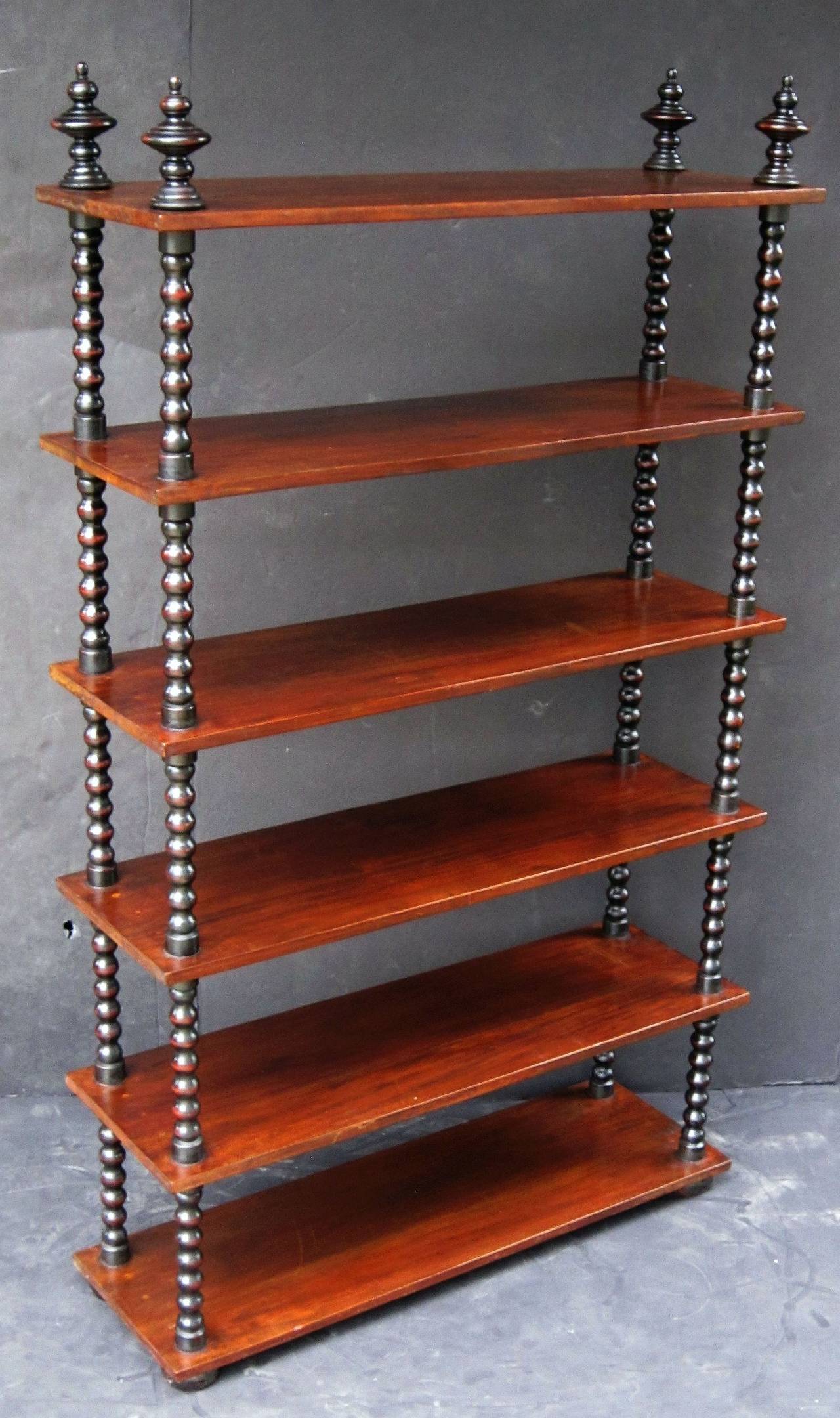 A handsome large English bobbin-turned shelving unit or shelves of mahogany, featuring six rectangular shelves attached to four bobbin-turned supports, with finial tops.