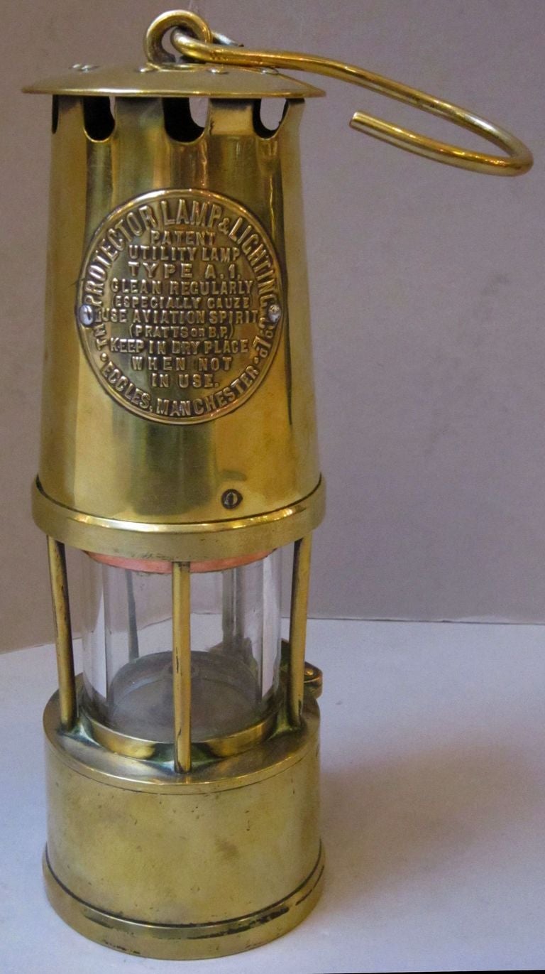 An English miner's lamp or safety lantern of brass in working order.
With maker's label and instructions: 
The Protector Lamp & Lighting Co. Ltd.  -  Patent Utility Lamp, Type A.1., Clean Regularly (Especially Gauze), Use Aviation Spirit (Pratt's