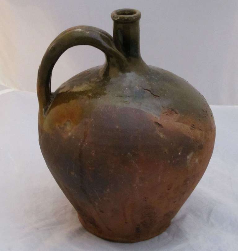 A 19th century rare form French jug sometimes known as a plongeon and a fine example of pottery from Southern France. Featuring a green and rust colored glaze over earthenware.

Part of a collection of rare form jugs - See last photo.

Please