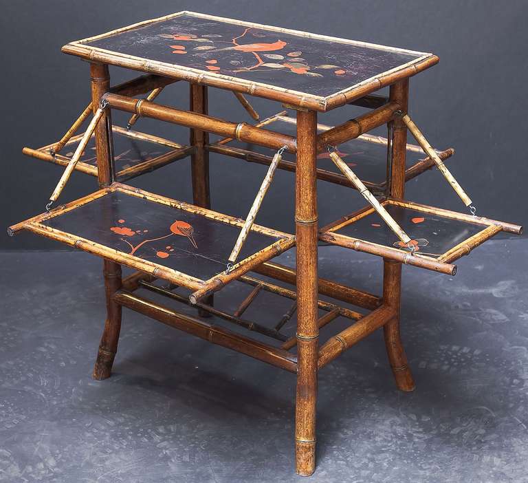 An English bamboo occasional or tea table featuring a lacquered top with a japanned scene of birds, with four opposing fold-out lacquered sides that function as serving trays, and set upon a four-legged stretcher with bamboo accents.

Dimensions