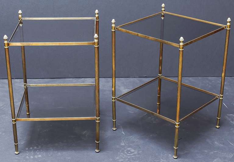 A pair of stylish two-tiered square end tables, each having finials and reeded legs of brass, with two smoked glass panels.

Would make great side tables, occasional tables, or night stands.

Priced individually: $1695 each table