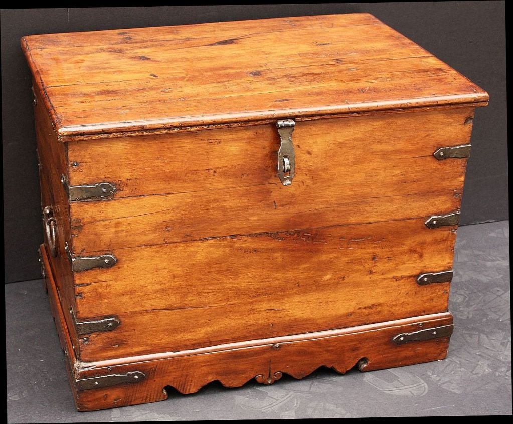 An English Campaign-era military officer's trunk of iron-bound wood. Featuring iron bindings, hinges, handles, and latch as well as plank wood construction. The lid opens to an interior with fitted compartments. Resting on a raised bracket base