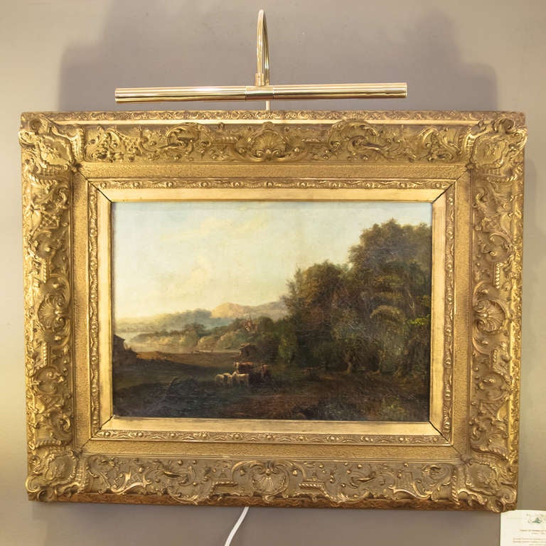 An early French oil painting or landscape of a rural country scene showing a farmer tending to his animals in a clearing near a forest's edge.

The canvas mounted to a decorative gilt frame, ready for hanging.