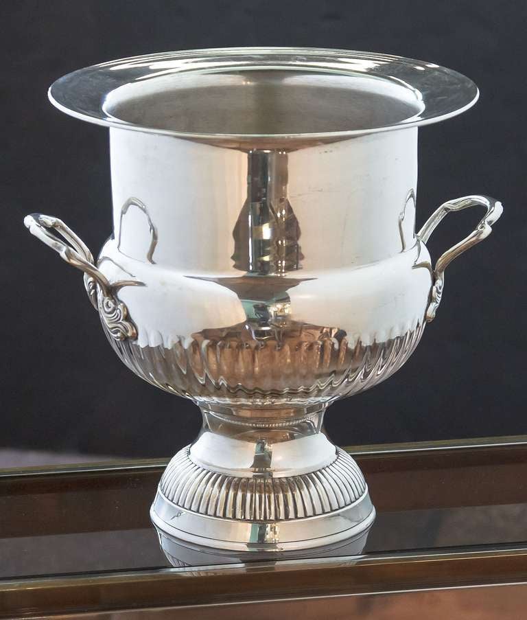 A handsome large French champagne bucket or wine cooler of plate silver, featuring an urn-shaped body with opposing handles on a raised, fluted base.
Champagne bucket: $1495

Champagne Bucket Dimensions: H 14.25