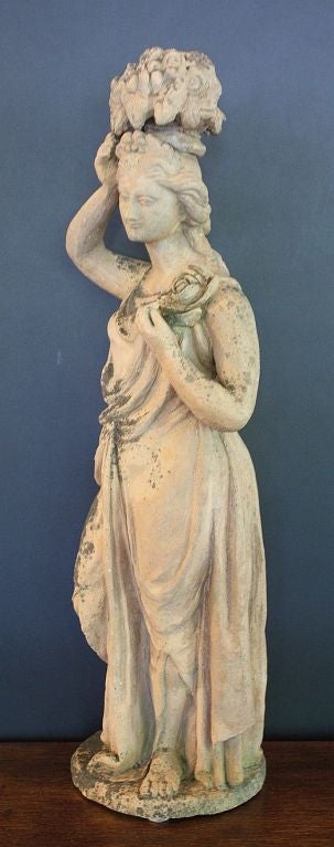 A lovely English garden statue or garden ornament of terracotta earthenware featuring a maiden or lady in Classical dress with her right hand holding up a floral bouquet, her left arm on a rosette.

Perfect for a garden room or conservatory!