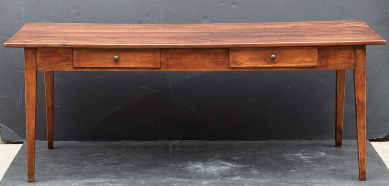 A French farm table of cherry featuring a lovely paneled rectangular top on a pegged frame with two drawers on side, standing on tapered legs.

Makes a fine dining or breakfast table.