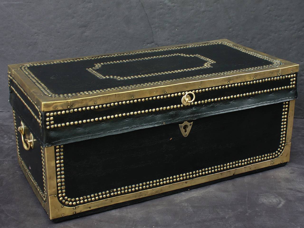 A handsome medium-sized British officer's military Campaign camphor trunk or chest of brass-bound and studded leather over camphor wood, circa 1820. 
Manufactured by the Dutch East India Company for an officer to carry his kit on Campaign. 
With