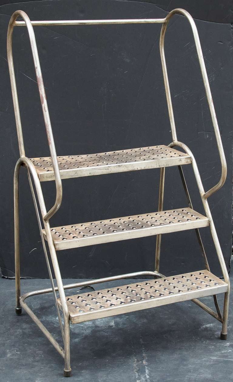 An English industrial step ladder of sturdy steel construction. 
Each step has perforations making a nice tiered plant stand
Great little step ladder for many interior uses - a great pantry or library ladder!