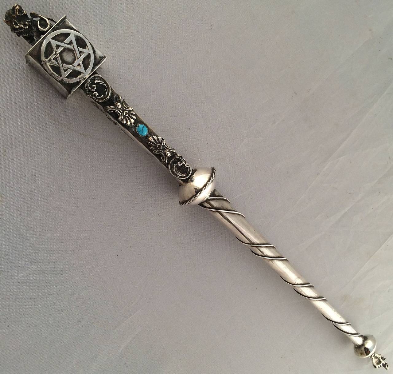 A fine Jewish yad or torah pointer of silver featuring a Lion of Judah on the handle end with a traditional pointed finger hand on the other end. With decorative blue stone and Star of David. A handsome find for the Judaica collector.

A yad
