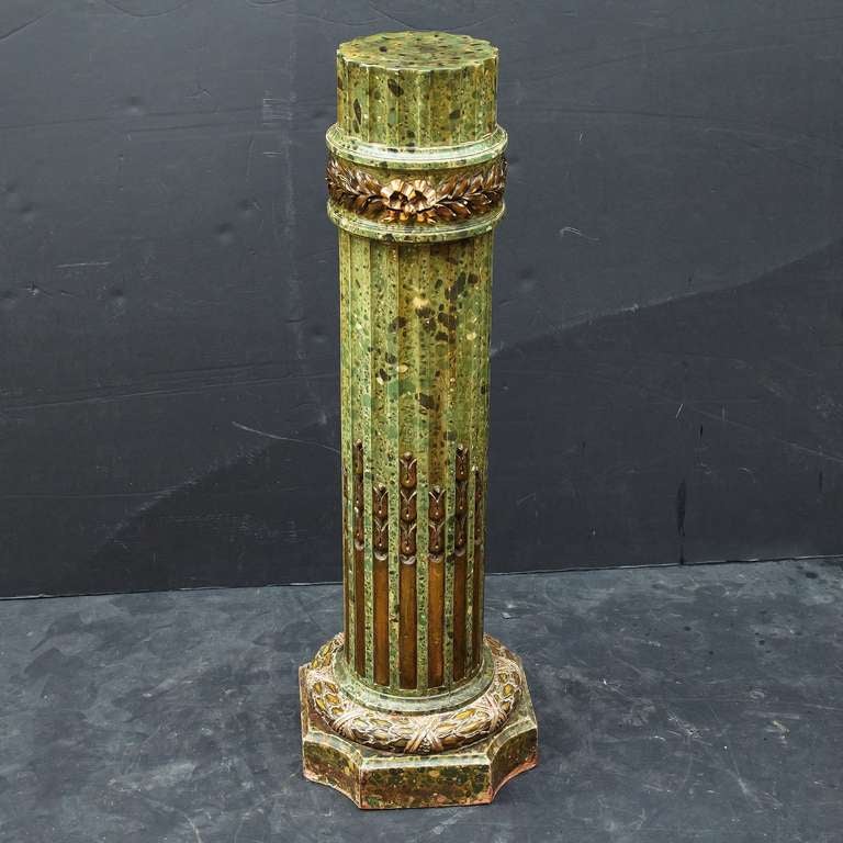 A handsome English column pedestal or stand of faux green marble (painted on carved wood), featuring a Regency design of gilt laurel leaves and ribbon bows around the top and bottom, with stylized gilt foliate accents.

A great display stand for a