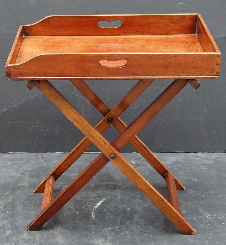 A classic English butler's tray on folding stand, featuring a removable large rectangular serving tray of mahogany, set upon a folding stand of mahogany with canvas straps.

Perfect for your next Downton Abbey viewing party!