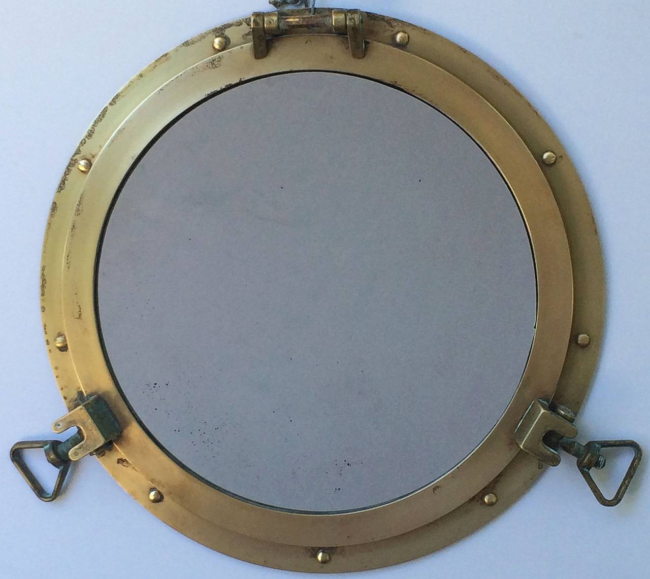 A handsome selection of three French ship's porthole mirrors of brass, each mirror (18 1/2