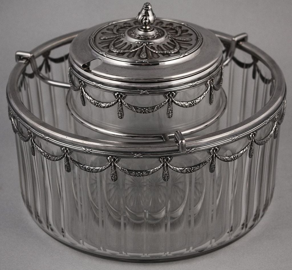 A caviar server by the celebrated decorative arts firm, Baccarat. <br />
Featuring a large cylindrical bowl of crystal glass for ice, with a silver overlay garland design around the circumference. A fitted holder for the caviar serving container,