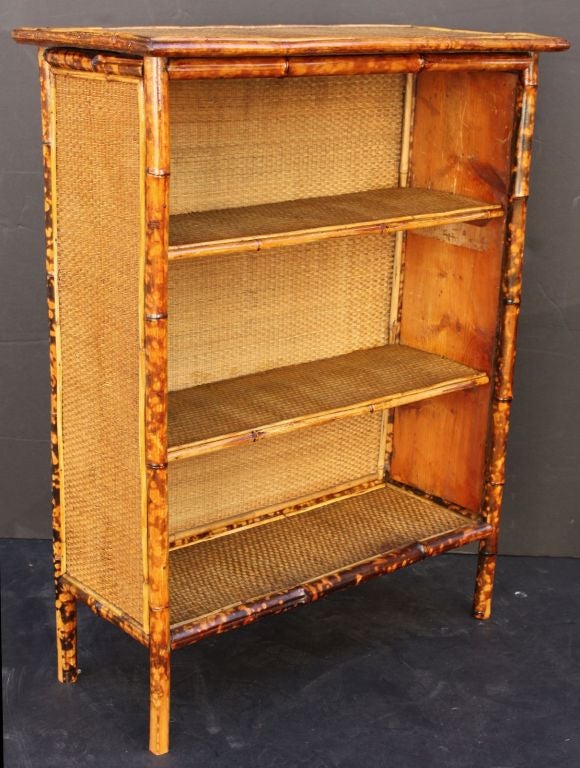 A fine English bamboo bookcase featuring open shelving.<br />
With seagrass accents to the top, sides and shelves and a tortoise-shell finish to the bamboo.