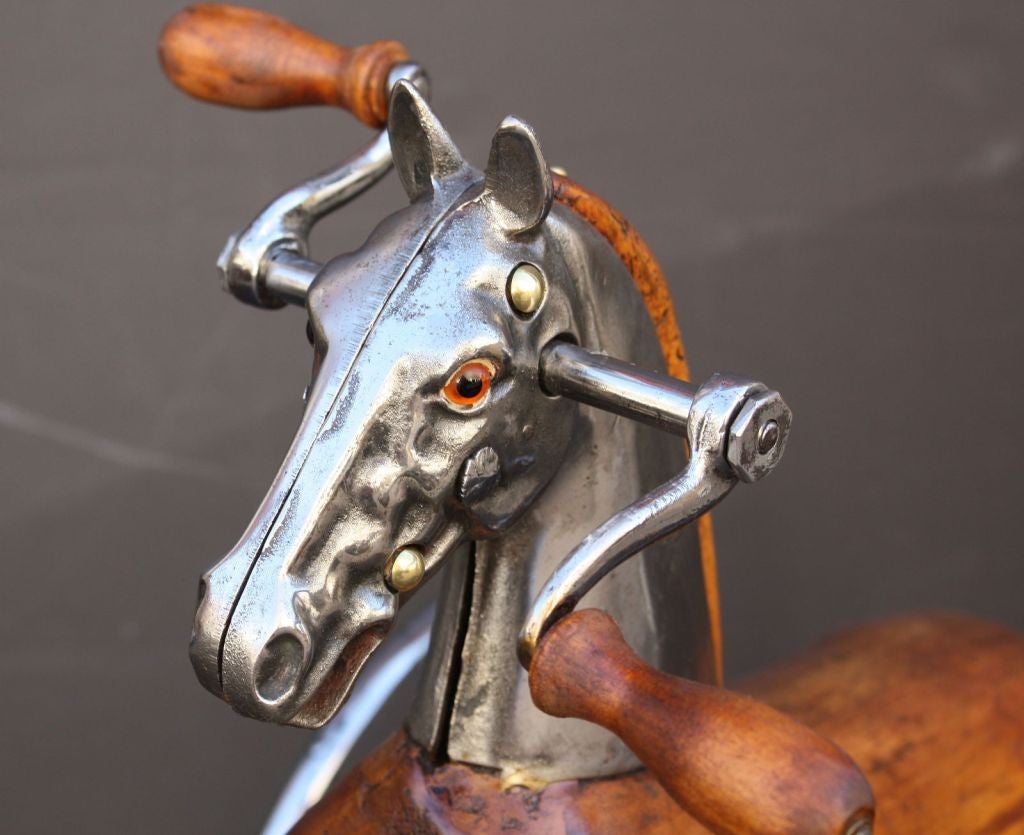 A 19th c. French velocipede or child’s toy tricycle featuring a body of carved wood with brushed steel faceplate and glass eyes, resting on spoke wheels with brass accoutrements and horse-hair tail.<br />
<br />
A handsome objet d'art similar to