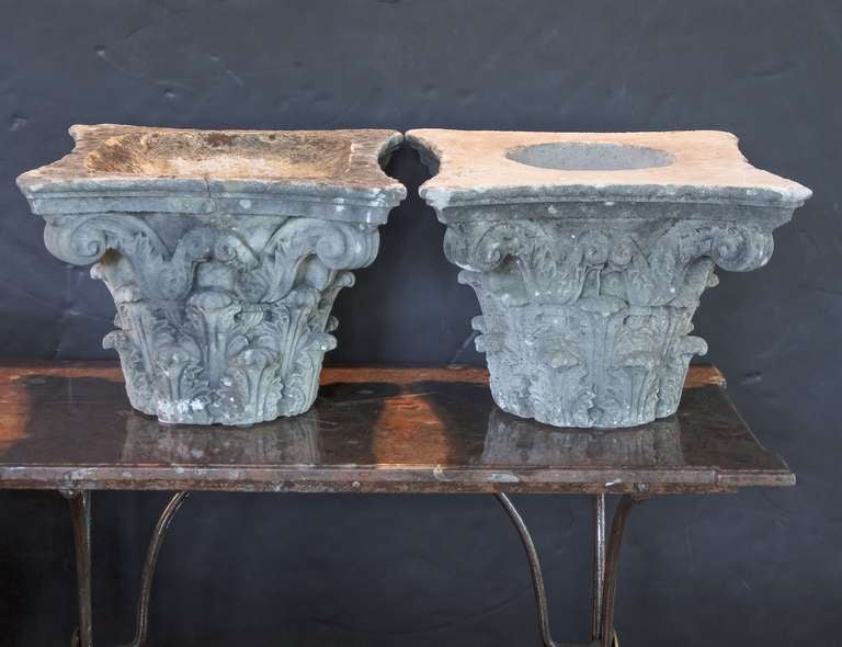 A pair of large English garden ornamental or decorative capitals of composition stone, each featuring a Classical design of acanthus leaves.

Perfect as end tables or for a garden room or conservatory or library!

Two available - Individually