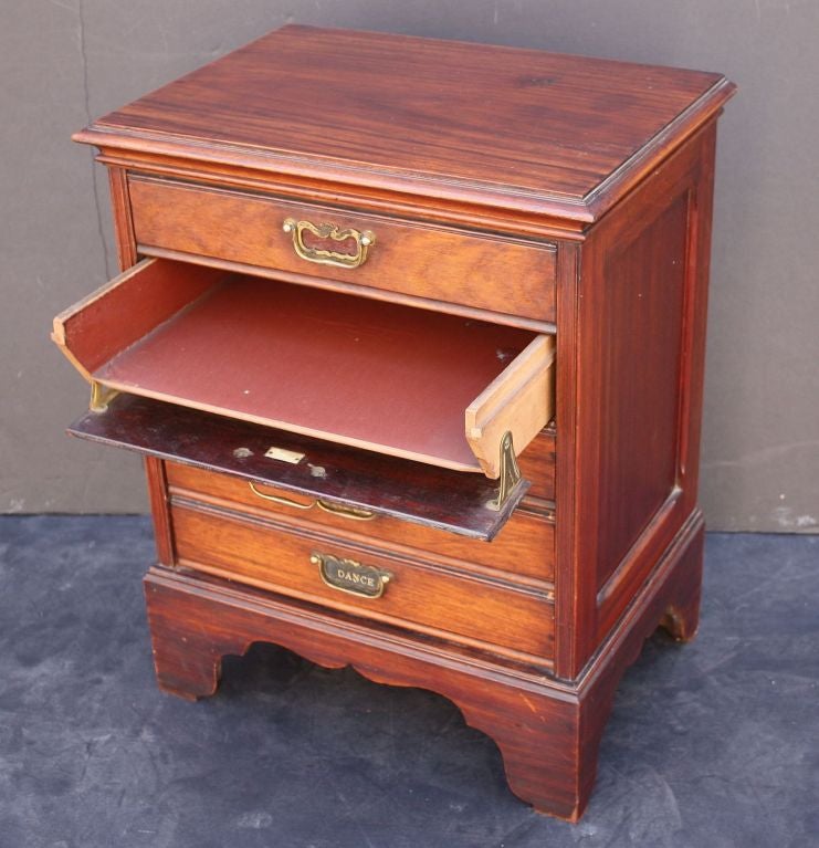 An English music (small) chest of mahogany featuring a moulded top over five drawers, each with brass pulls, and set upon bracket feet. Each drawer (when pulled) folds down for easy access and storage of sheet music. <br />
<br />
Great for the