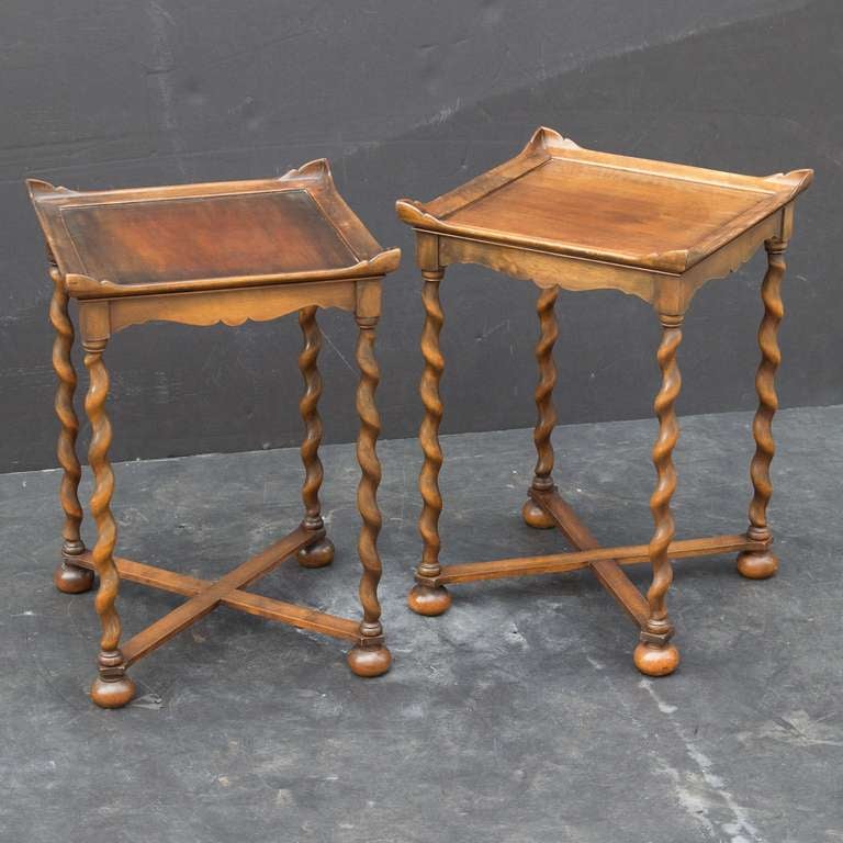 A handsome pair of English end or side tables, each table featuring a pagoda-like moulded top with flared corners over a frieze apron with four barley twist legs and crossbar stretcher. Standing on ball feet.

Might make a great pair of bedside or