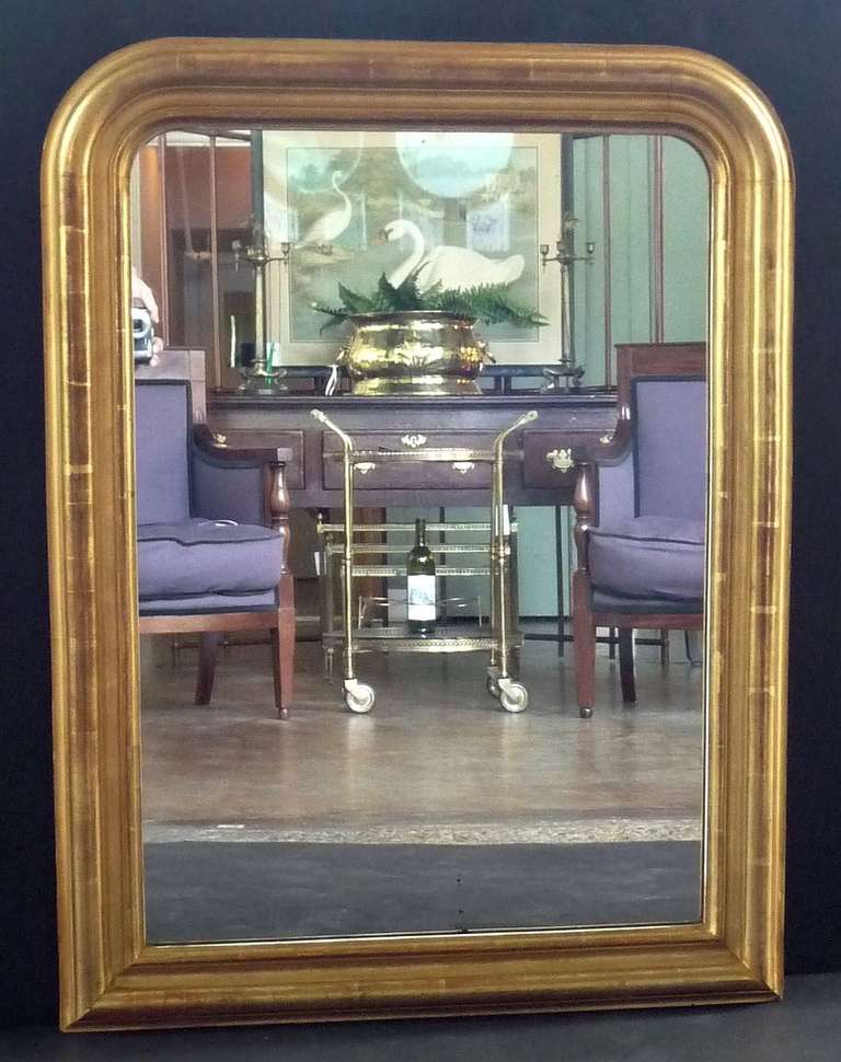 A handsome large French gilt mirror in the Louis Philippe style, featuring a lovely warm patina around the circumference of the moulded frame.

Dimensions: H 35 1/2