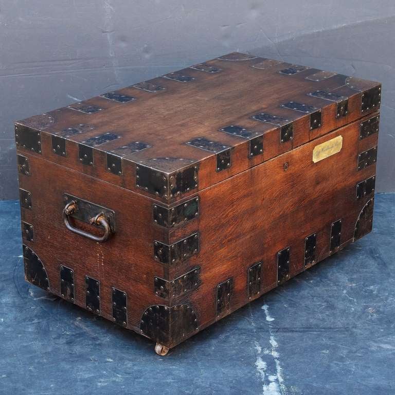 A handsome Campaign-era boarded chest or trunk, bound in iron, featuring a hinged lid with iron clasp, iron handles, an interior of panelled wood, and resting on rolling casters. With brass name plate reading: Jas. Woodbridge,