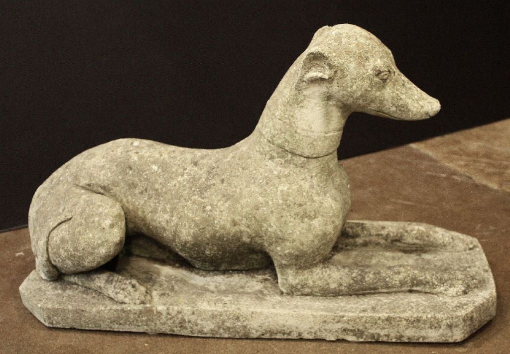 An English garden statue of composition stone featuring a reclining greyhound or whippet, collared, its tail upon its hind leg.<br />
<br />
Perfect for a Garden Room or Conservatory!