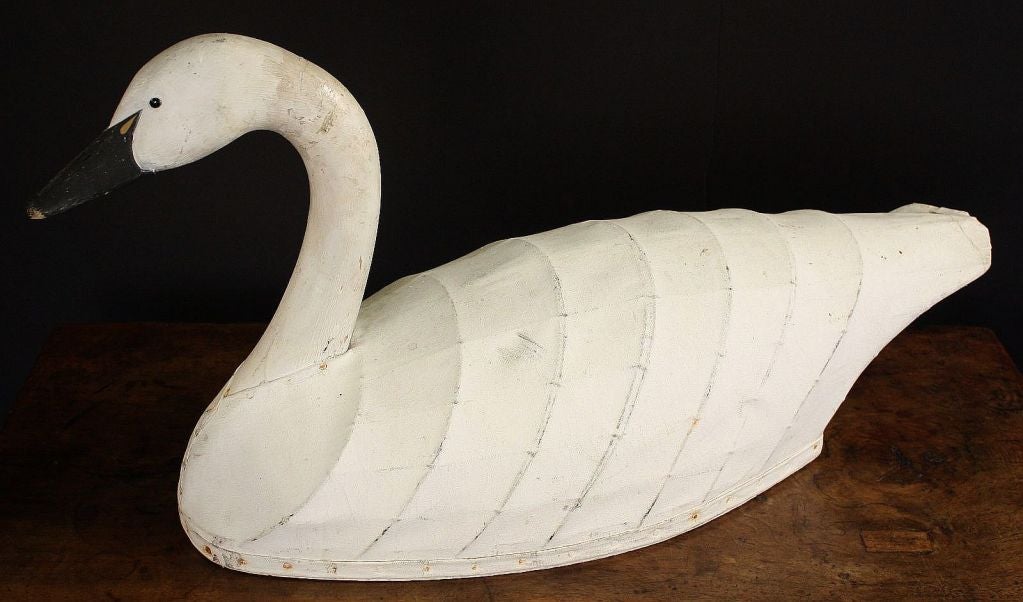 An early American confidence decoy of a swan featuring a carved and painted wooden head and neck attached to a body of canvas over a wood and metal frame.<br />
<br />
A great example of American primitive folk art - graceful lines and handsome