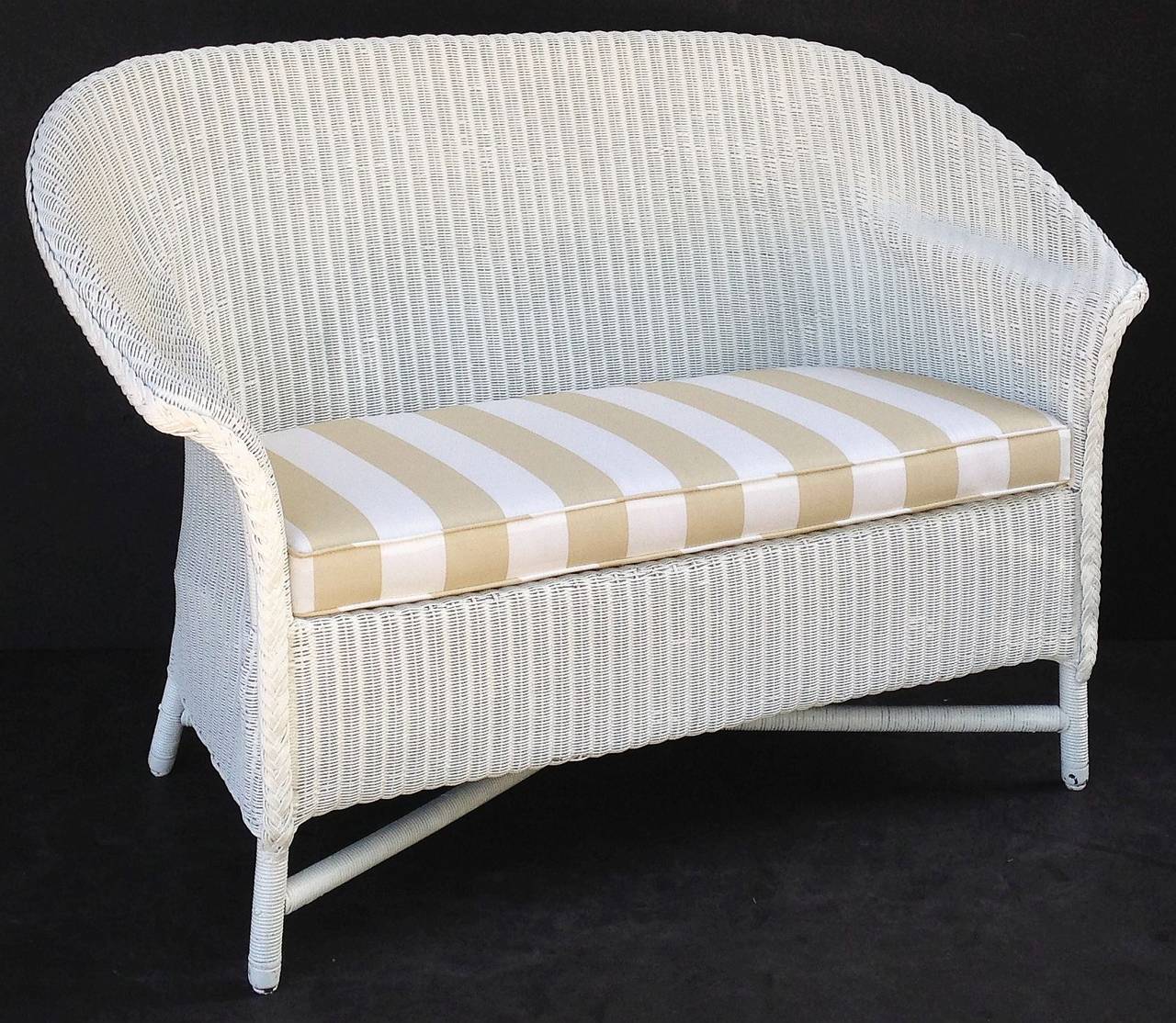 A Lloyd Loom sofa, synonymous with Classic English style.

Perfect for the garden room or conservatory, this handsome sofa features the vintage look and comfort one only finds in the original, pre-War series. A flowing, serpentine back of woven