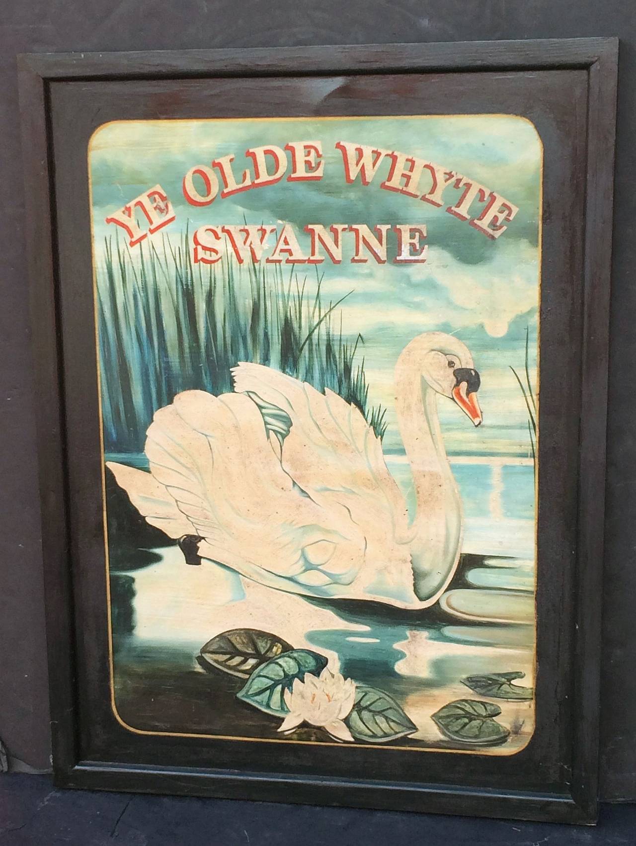 An authentic English pub sign (one-sided) featuring a scenic painting of a swan upon water, with water lilies in the foreground and reeds in the background, entitled: Ye Olde Whyte Swanne

A very fine example of vintage advertising artwork, ready