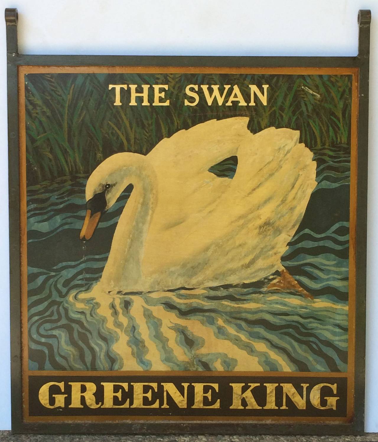 An authentic English pub sign (two-sided) featuring a painting of a swan on water among reeds, entitled: The Swan, from an original Greene King pub.

Marked: Greene King (Greene King is a British brewery established in 1799 in Bury St Edmunds,