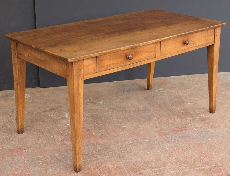 A French farm table of walnut featuring a handsomely paneled rectangular top on a pegged frame with tapered legs and two side by side drawers. 

Makes a great writing table or desk  -  Also nice as a dining or breakfast table.