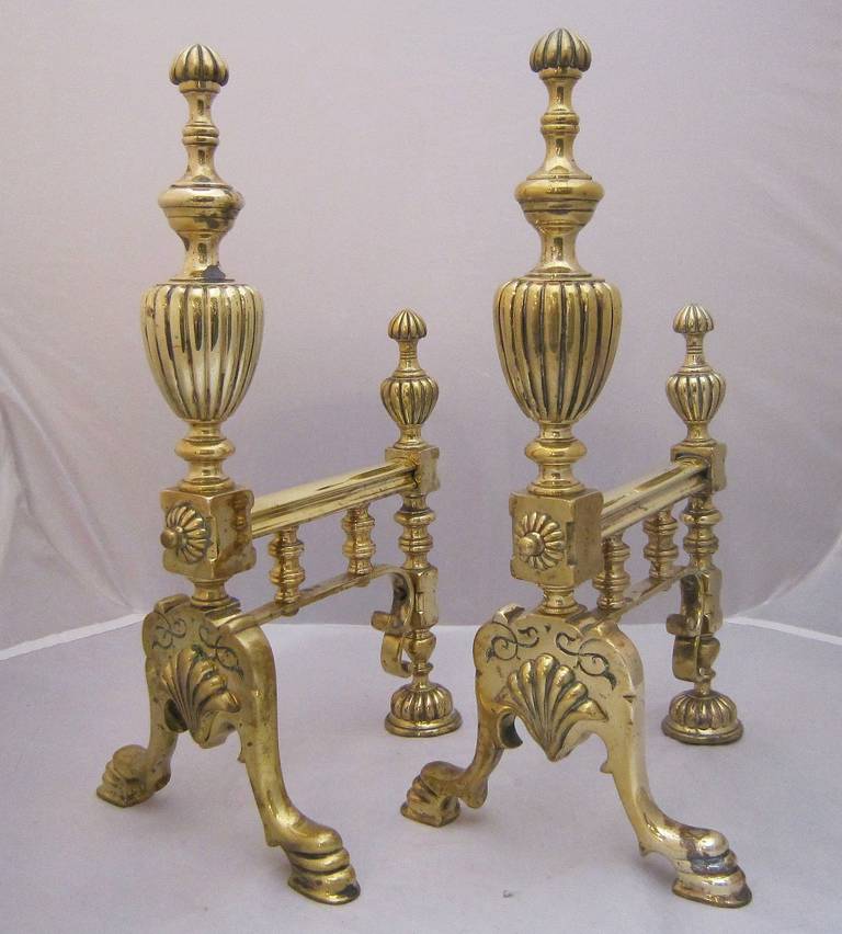 A handsome pair of English brass andirons or fire dogs featuring a design of urns and hoofed feet.

An exquisite addition to the fireplace or hearth.

Sold as a pair: $2295 pair.