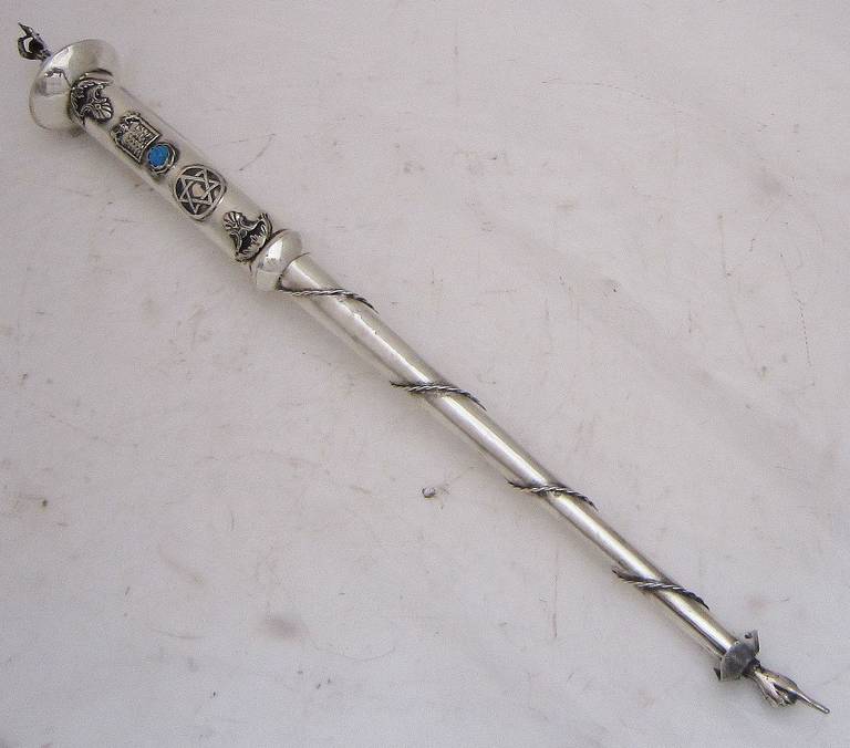 A fine Jewish yad or torah pointer of silver featuring a robed man playing a violin or fiddle on the handle end, with a traditional pointed finger hand on the other end. With decorative blue stone. A handsome find for the Judaica collector.

A yad