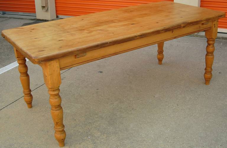 A fine English rectangular farm table of pine, featuring a moulded top with a handsome patina, on a stretcher with turned leg supports. Seats six to eight easily.

Great for a dining or breakfast table.