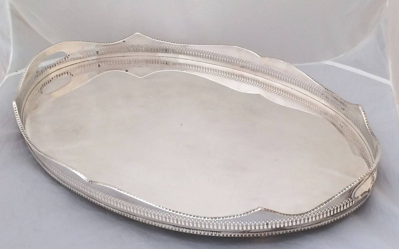 A handsome English oval gallery serving tray with pierced serpentine gallery around the circumference. Of fine English plate silver.

Dimensions: Gallery H 3