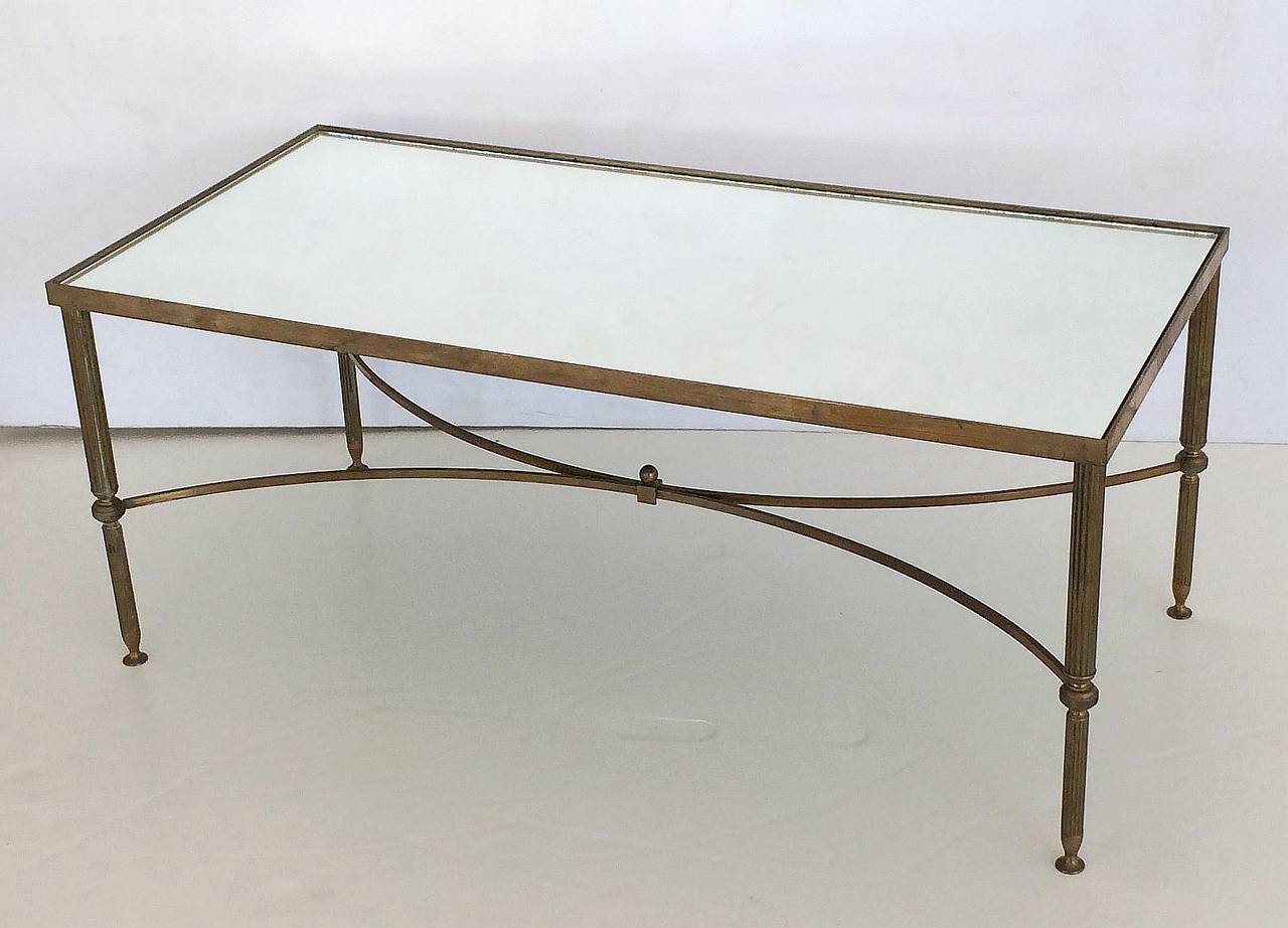 A large French rectangular low or coffee table (or cocktail table) featuring a stylish frame of brass on reeded legs, with mirrored glass top.

Dimensions: H 16 3/8