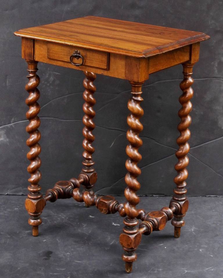 A French side table featuring a lovely moulded top of rosewood and frieze with small drawer and pull, mounted to a handsomely turned barley-twist stretcher.