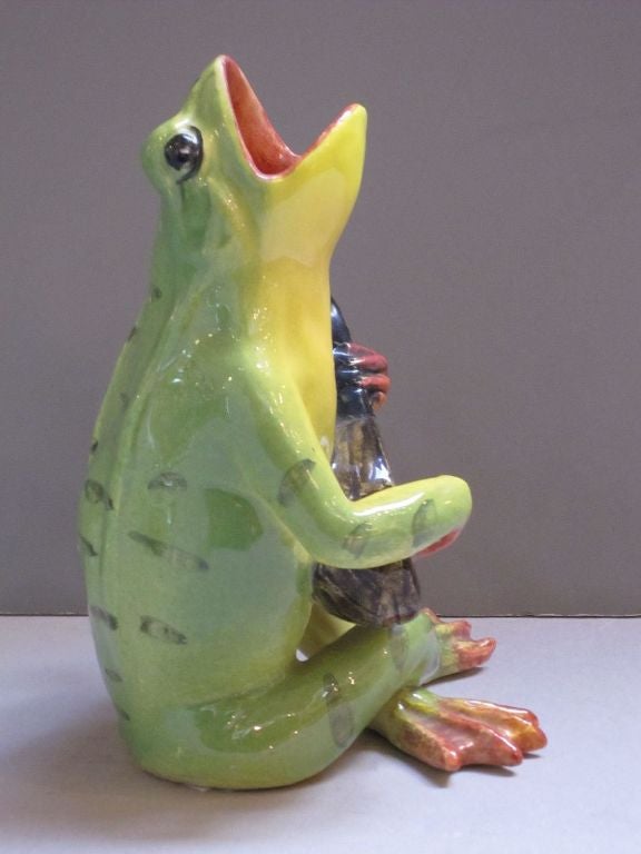 A handsomely-modeled Majolica frog by the celebrated French pottery firm, Massier. Featuring a sitting frog singing and playing the guitar.<br />
<br />
A similar frog is pictured on page 156 in the book, Massier - L'Introduction de la Ceramique