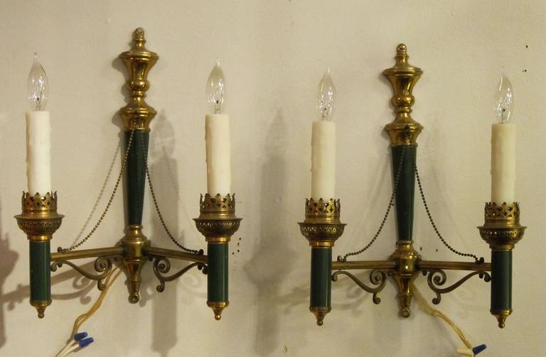 A handsome pair of Empire or Regency style two-arm wall lights (or sconces) of brass with painted accents of green enamel.

U.S.-wired - Ready for display.

Priced as a pair: $2450 the pair.