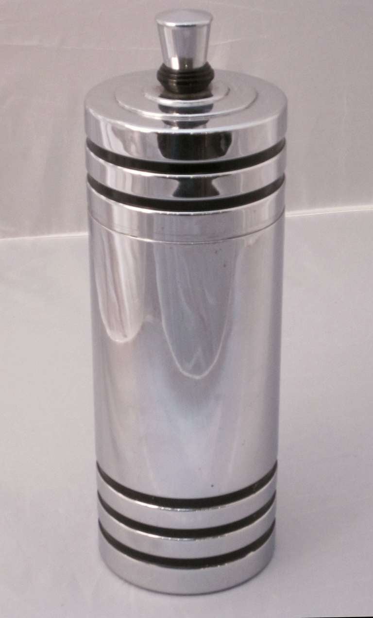 A handsome Art Deco or Prohibition-era Chase Gaiety cocktail shaker in chrome and bakelite. Produced in the 1930’s, this shaker is considered an iconic piece of art deco design, featuring a chrome body accented with black bands and a bakelite band