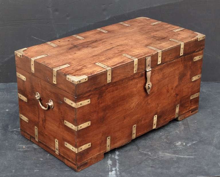 A handsome English military officer's Campaign-era trunk of teak featuring hand-cut brass binding and hardware, with interior compartments, and resting on square cut feet.

Campaign-era trunks and coffers were the travel items of British military