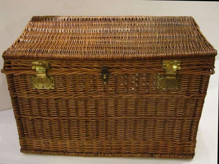 A large French basket hamper of woven willow with brass hardware.