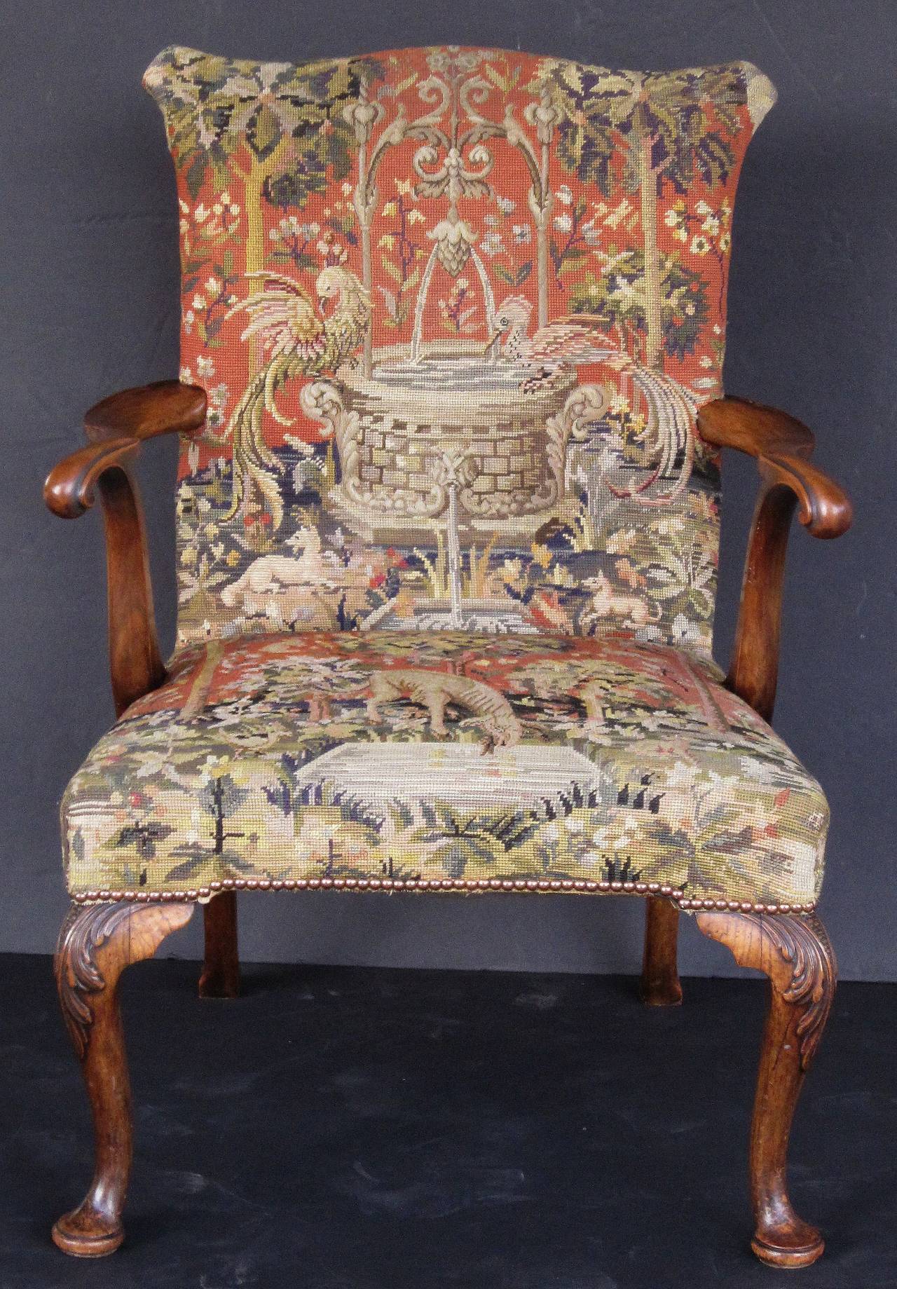 A handsome large English open armchair in the Gainsborough style, featuring a decorative needlepoint tapestry upholstered over a walnut frame, stylish serpentine arms and carved cabriole legs.

H 38 3/4