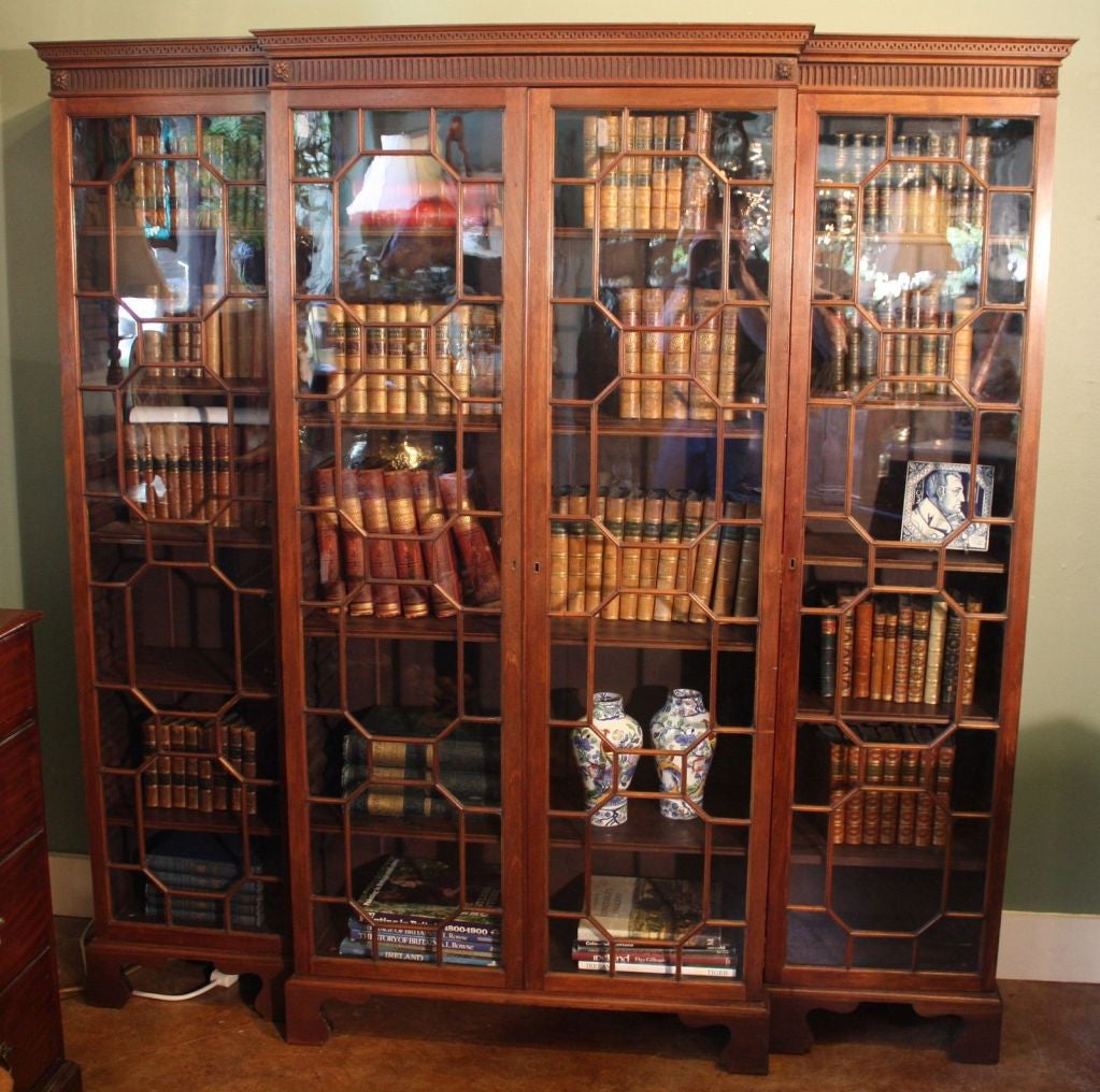 A Chippendale style breakfront bookcase of mahogany from the Edwardian era, featuring three locking sections with adjustable shelves. Bought in Scotland, this bookcase has a center breakfront section flanked by two sections, each section with