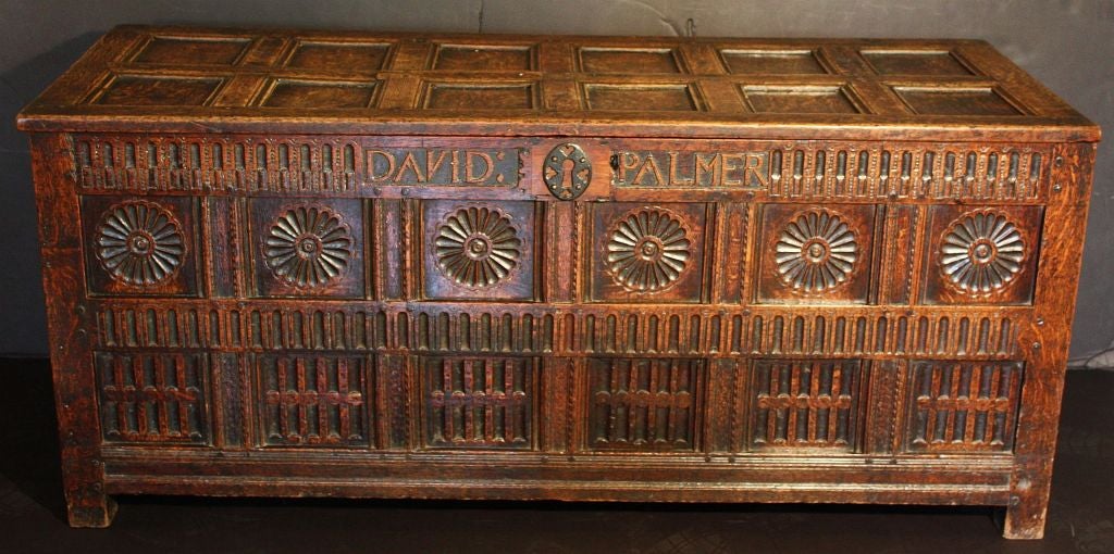 An English joined chest or coffer (trunk) of oak from the Restoration Period, c.1660, featuring a multi-panelled top and sides with original linen-fold carving and decorative roundels on the facing panel, with iron escutcheon and hardware. Fine