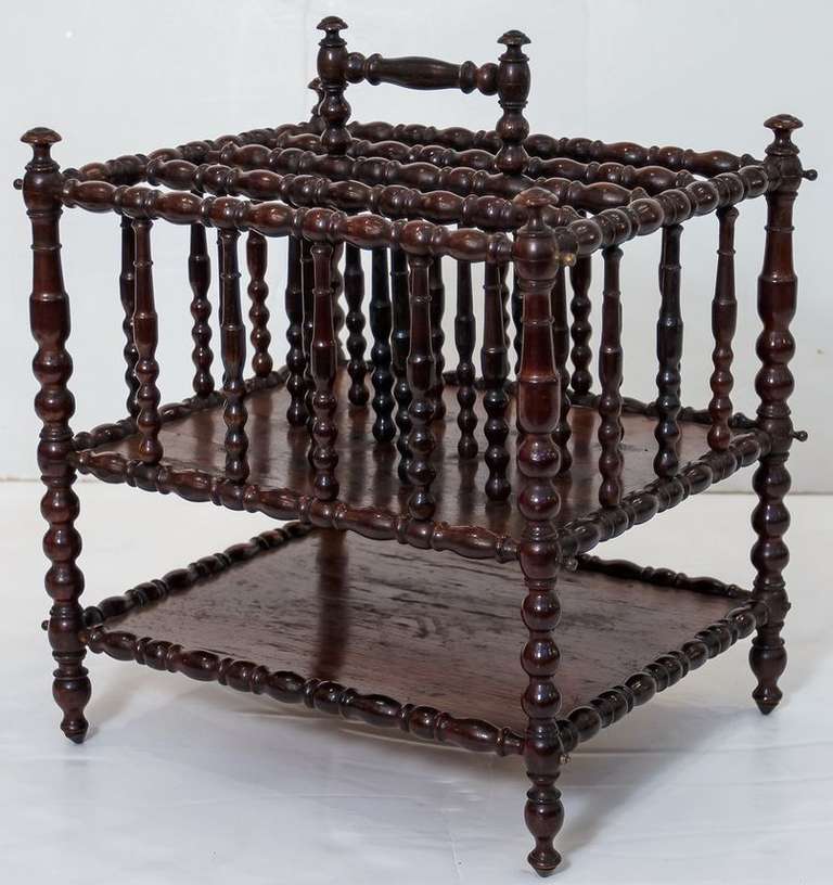 A handsome English canterbury (for sheet music) or magazine rack featuring a frame of turned spindles mounted to two tiers, with handle at top.